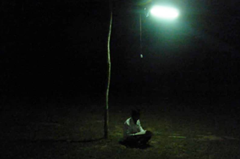 街灯の下で勉強する少女