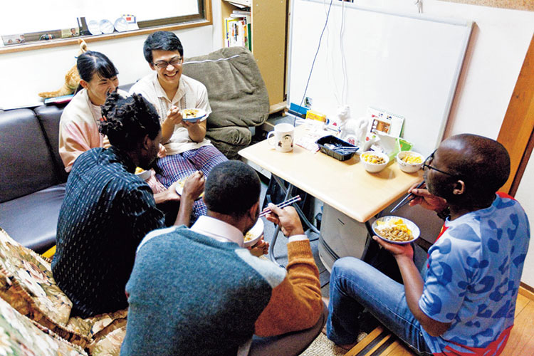 食事する難民の画像